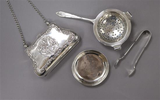 An Edwardian silver purse, Birmingham, 1904, a pair of silver sugar tongs and a silver tea strainer on associated stand.